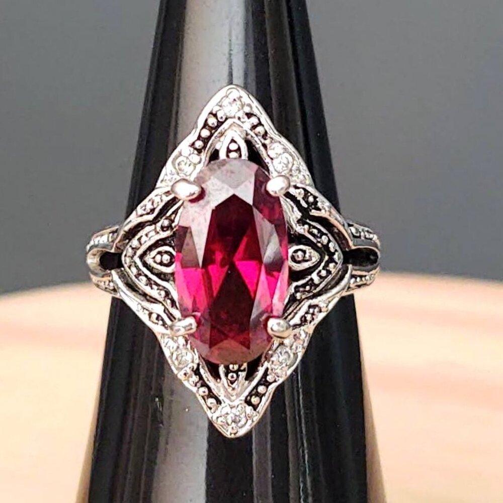 Silver tone ring with ruby/garnet faux stone and faux diamond accents